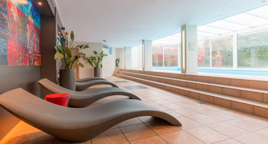 Luxe ligstoelen bij binnenzwembad van Fletcher Resort-Hotel Zutphen